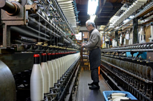 よりを掛けながら糸を巻き取る機械が軽快な音をたてる撚糸工場。景気悪化で組合加盟業者は激減した（京都市北区） / 京都新聞