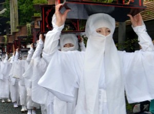 神々への供物入れを頭上に頂いて神幸行列を行く白装束の女性たち＝２８日、熊本県阿蘇市 / 西日本新聞