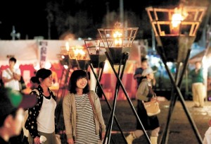 八幡川への感謝の思いを表すかがり火が並んだ祭り会場 / 河北新報